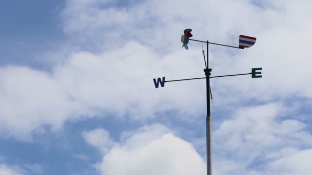 Kierunek wiatru lub wiatrowskaz z North South East West znak lub symbol, na tle błękitnego nieba — Wideo stockowe