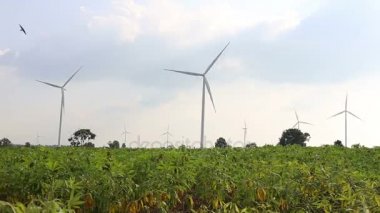Gökyüzü güneşin ve bulutların arka plan ile elektrik üreten Rüzgar türbinleri.
