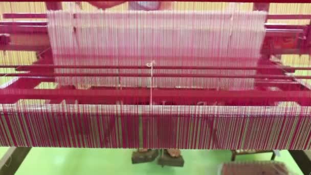 Met behulp van een traditionele loom machine met garen brokaat weven — Stockvideo