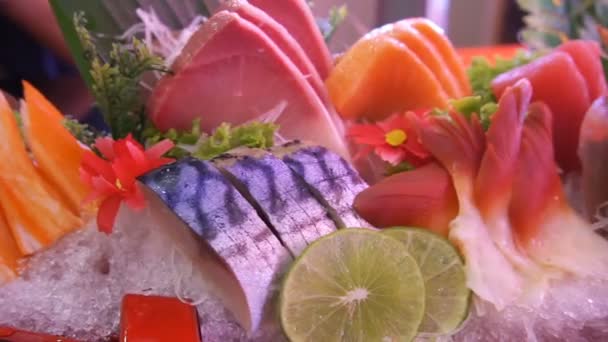 Okokt färsk lax och röd tonfisk och saba och tioarmad bläckfisk och krabba med grönsaker och frukter delar serveras över träskiva. — Stockvideo