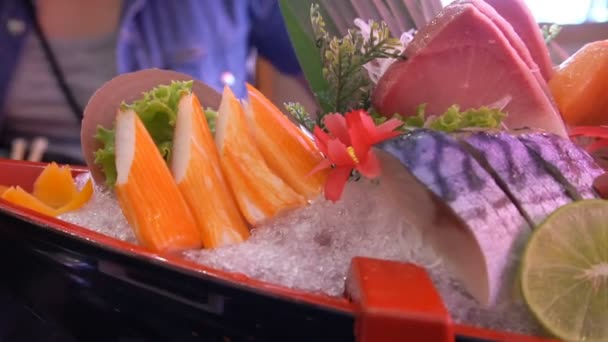 Ongekookte verse zalm en rode tonijn en saba en pijlinktvis en krab met groente en fruit zetstukken diende over houten plank. — Stockvideo