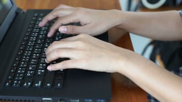 Les mains de la femme tapant sur ordinateur portable clavier THAI sur table en bois (1080HD ). — Video