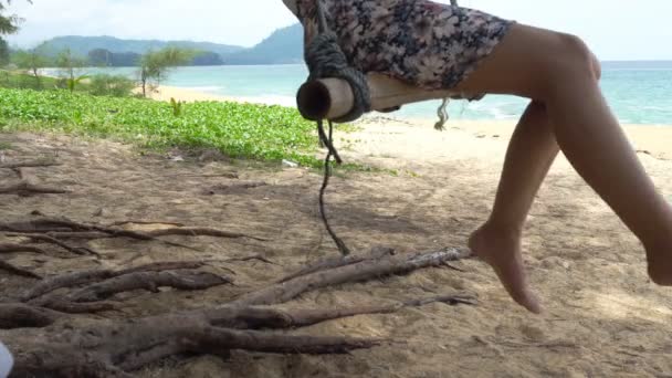 在泰国普吉岛的一个夏日 在热带海滩上 在蓝色的海洋和天空背景下 妇女摇摆放松和享受一个木秋千 Uhd — 图库视频影像