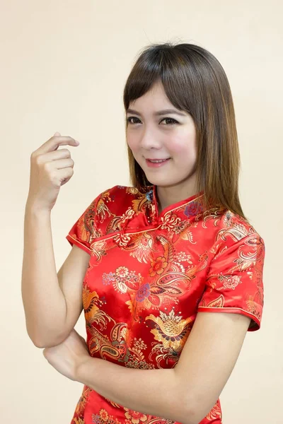 Closeup of asian woman greeting in traditional Chinese or cheongsam in chinese new year celebration in red golden style