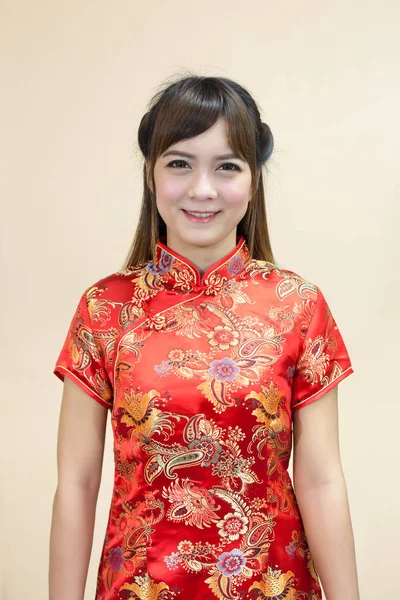 Closeup of asian woman greeting in traditional Chinese or cheongsam in chinese new year celebration in red golden style