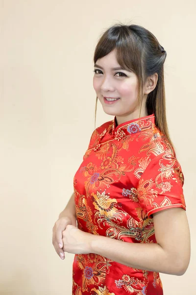 アジアの女性の伝統的な中国語または手上げ歓迎式とチャイナ ドレスのご挨拶と幸運赤黄金スタイルで中国の新年のお祝いに — ストック写真