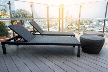 Şehir manzaralı modern binasında iki şezlong üzerine gelin.