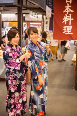 Japon geleneksel kimono giyen iki genç kadın zevk yürüyüş içinde Japonya çarşı