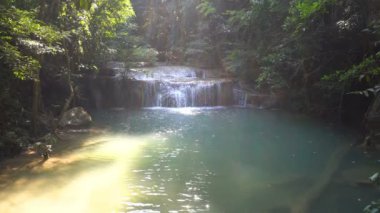 Kanchanaburi, Tayland 'da Erawan şelalesi. Ormanın derinliklerindeki zümrüt havuzlu güzel şelale doğa ve antimon balığı.