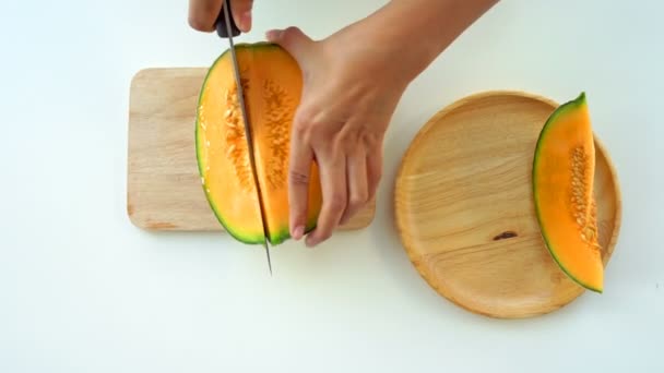 Skär Melonen För Hand Vilar Träbricka Ett Vitt Bord — Stockvideo