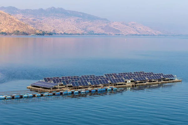 Solar cell lines arranged in rows on a river with a mountain background