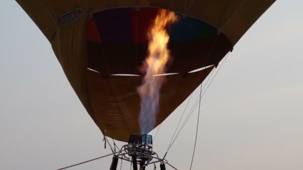 日没時に地面の上を飛んでカラフルな熱気球でプロパンガスバーナーのビデオを閉じます — ストック動画