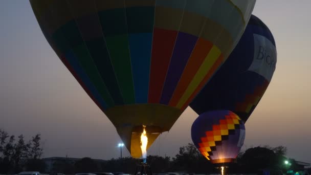 Färgglada Varmluftsballonger Som Flyger Över Marken Vid Solnedgången — Stockvideo