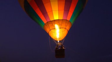 Propan gazı yangın ocağını renkli sıcak hava balonlarıyla yakın çekim yapın. Gece vakti yerin üstünde uçun.