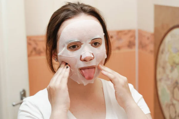 Una Chica Alegre Divertida Tonteando Haciendo Muecas Con Una Mascarilla — Foto de Stock