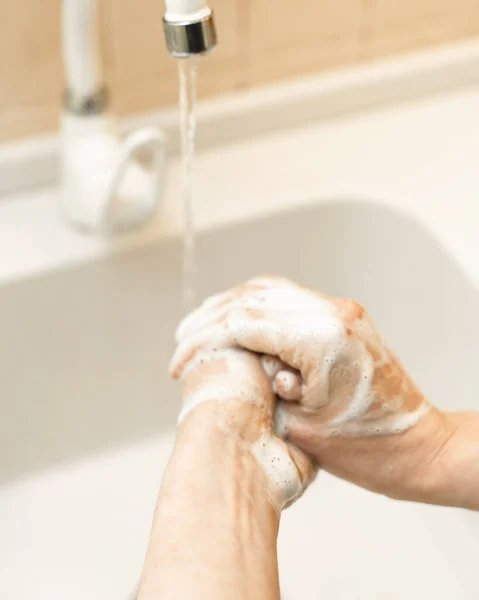 一个女人在洗手 她揉揉他的手掌 她洗手以保护自己不受Covid 19的伤害 — 图库照片