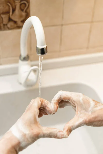 一个女人用肥皂洗手 用心脏握住她的手指 她洗手以保护自己不受Kovid 19的伤害 — 图库照片