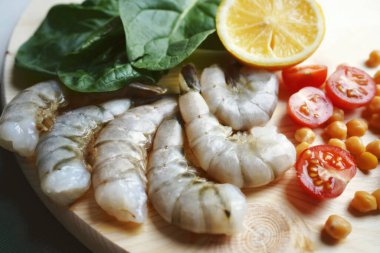  Limon ve ıspanakla pişirmek için soyulmuş Kral karidesleri 