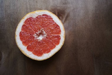 Koyu ahşap arka planda sulu greyfurt.