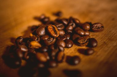 Tahta bir masada bir avuç aromatik kahve çekirdeği.