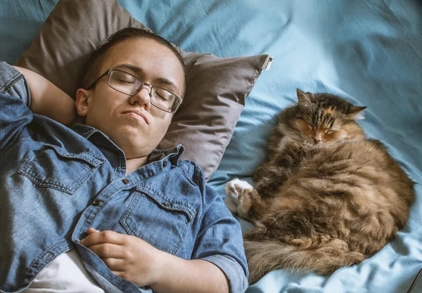 Nastolatek Okularach Dżinsowej Koszuli Kot Śpią Razem Niebieskim Prześcieradle — Zdjęcie stockowe