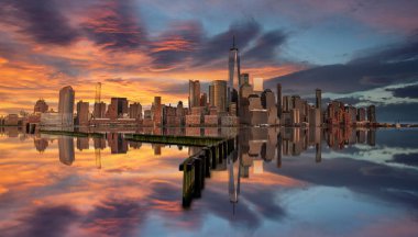 New York ve New Jersey silueti New Jersey güvertesinden gün batımına doğru mavi saatte Hudson Nehri 'ni yansıtıyor.