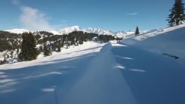 Fransız Alpleri 'ndeki kar vadileri üzerinde hava uçuşu. Karla kaplı ev ve ağaçların görüntüleri