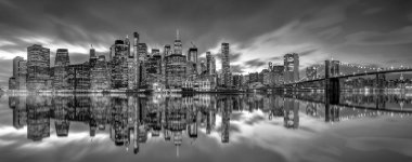 .Brooklyn Köprüsü 'nde gün batımında gökdelenleri olan New York City silueti siyah ve beyaz versiyonu