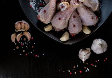 Siyah bir zemin üzerine baharatlı tavuk budu