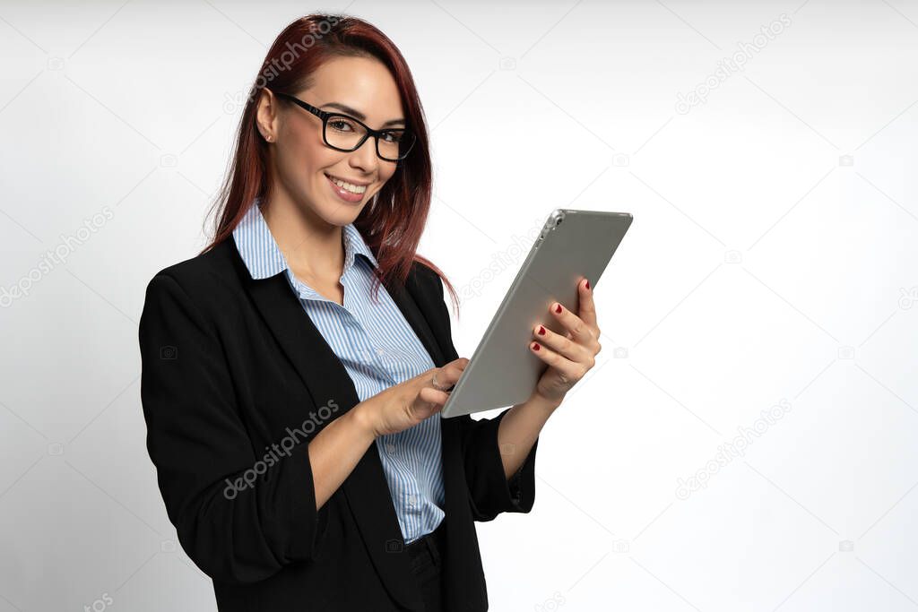 Confident happy smiling cheerful young business executive, worker or student woman with red hair wearing jacket and glasses