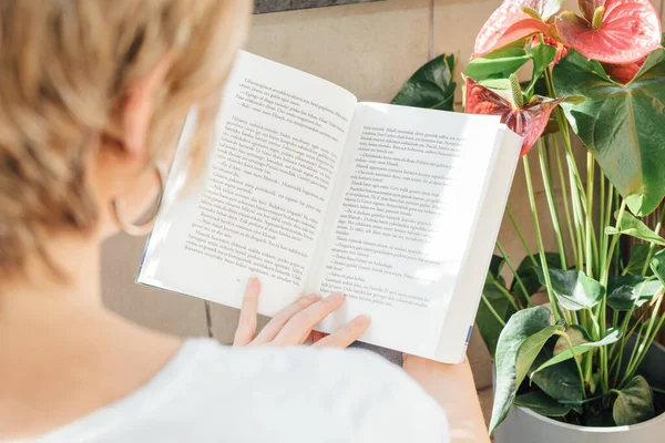 Sarışın Kadın Balkonda Kitap Okuyor Gün Batımında Etrafı Bitkilerle Çevrili — Stok fotoğraf