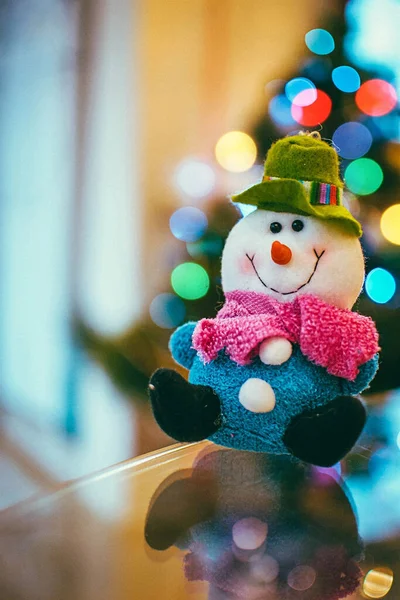 Noel oyuncağı kardan adam kış bokeh 'i ve bulanık arka planlı Noel ağacı arka planı