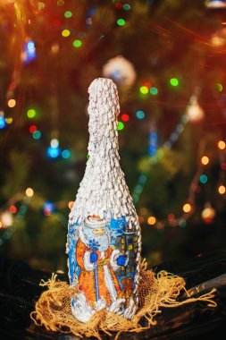 Noel ağacının arka planında yılbaşı ellerinin yaptığı şişe ve güzel bulanık bokeh arka plan..