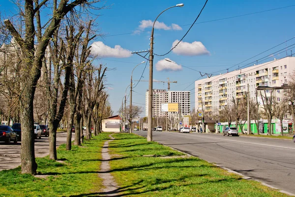 Güneşli bir günde mavi bulutlu bir gökyüzü ve evlere karşı şehir caddesinde trafik