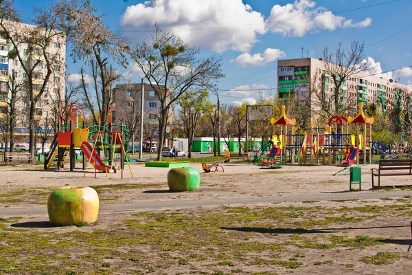 Şehirde çocuksuz bir çocuk parkı. Parkın bahçesindeki renkli çocuk parkı evlerle çevrili.