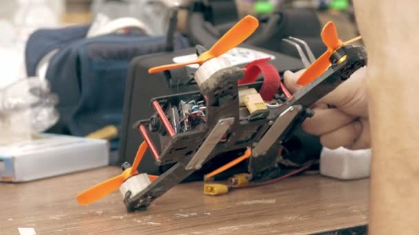 Человек собирает дрон FPV с помощью инструментов — стоковое видео