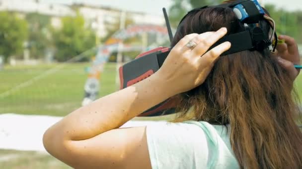 Femme corrigeant les lunettes VR pour piloter un drone FPV — Video