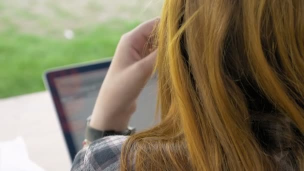 Over de schouder van de jonge vrouw met rood haar — Stockvideo