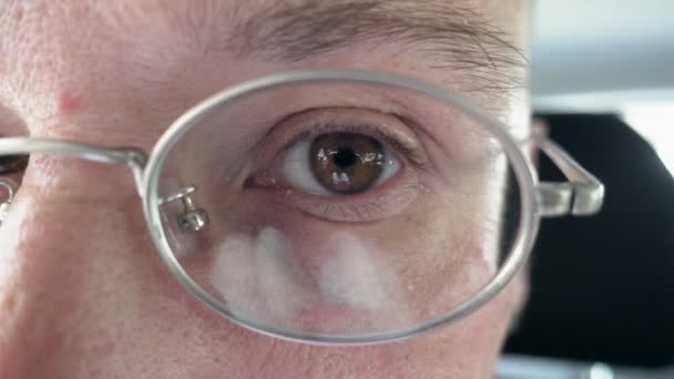 Persons brown eye through the metal glasses — Stock Video