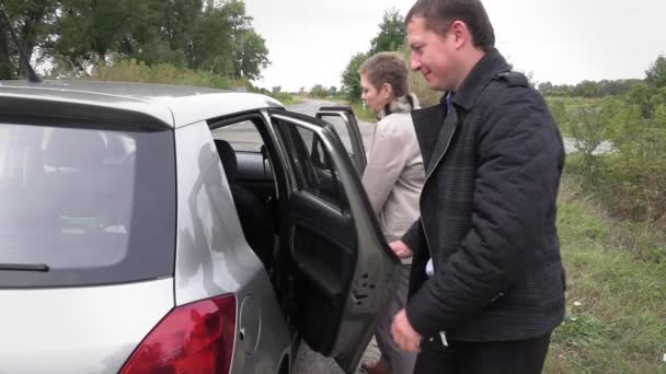 Férfi és nő bekerülni a kocsiból — Stock videók