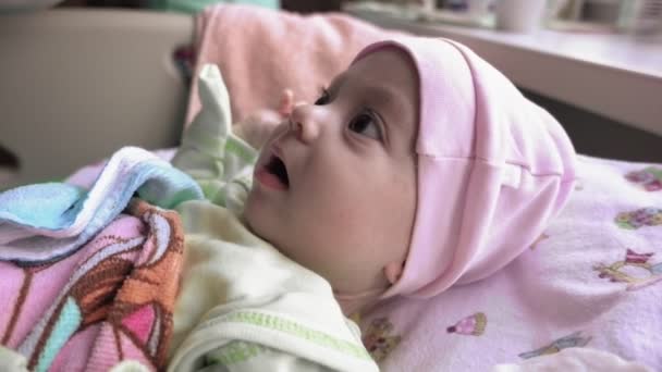 Новорожденный ребенок с большими карими глазами, оглядывающимися вокруг — стоковое видео