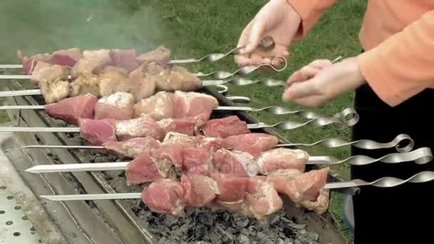 Девушка готовит шашлыки с мясом на жаровне — стоковое видео
