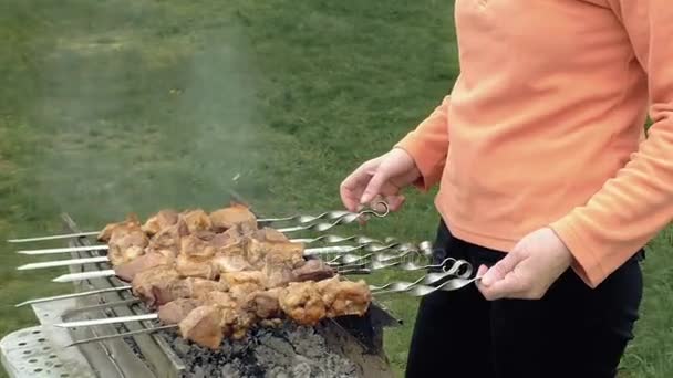 Menina cozinha espetos de churrasco com carne no braseiro — Vídeo de Stock