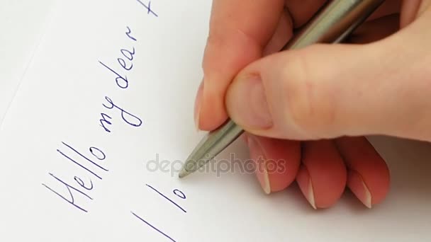 Vrouwelijke hand schrijft dat ik hou van je op het vel papier — Stockvideo