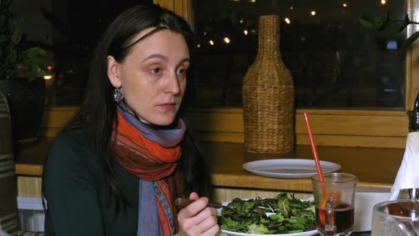 Beautiful woman talks to a friend in a restaurant — Stock Video