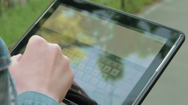 Kvinnan skriver texter på tablet pc promenader utomhus — Stockvideo