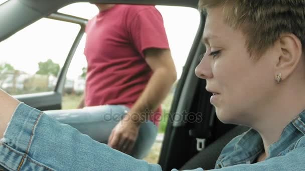 Homme et femme montent dans une voiture et descendent la rue — Video