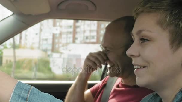 Casal no carro falar sorriso e rir e homem sai — Vídeo de Stock