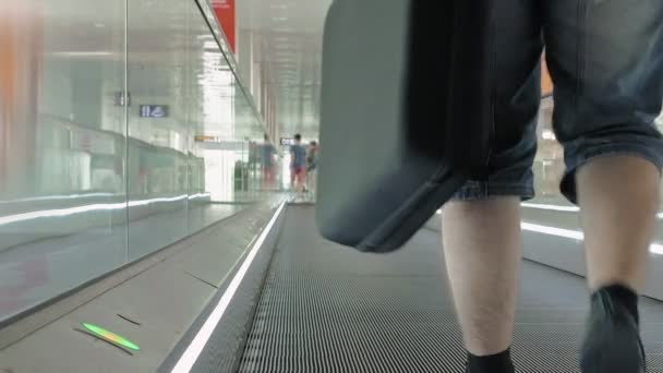 La persona está caminando por el camino en movimiento en el aeropuerto — Vídeo de stock