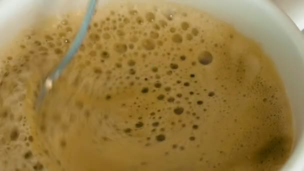 Una persona está revolviendo café caliente con una espuma — Vídeos de Stock